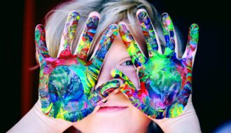 kid with colorful hands