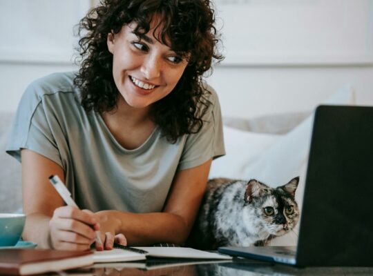 kobieta pracuję przy laptopie z kotem obok
